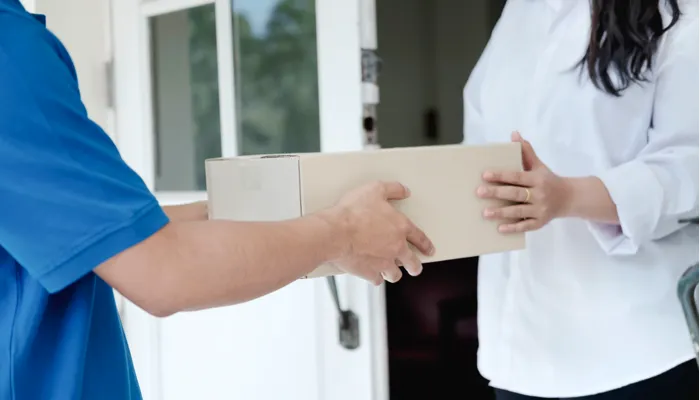 Delivery person handing a medical box to another person